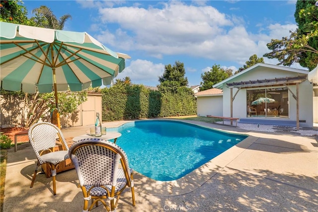 view of swimming pool with an outbuilding and a patio area