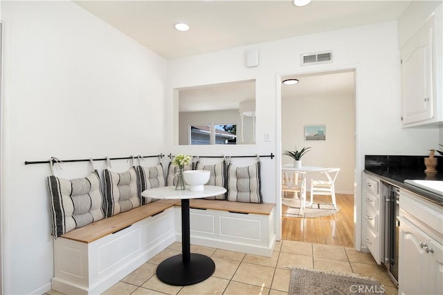 interior space featuring breakfast area, white cabinetry, and light tile patterned floors