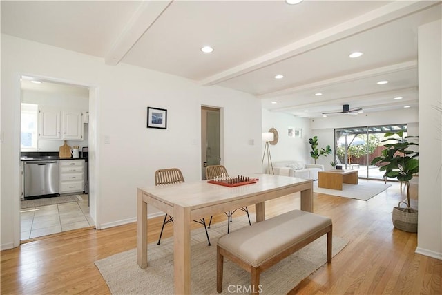 dining space featuring light wood-type flooring, ceiling fan, and beamed ceiling