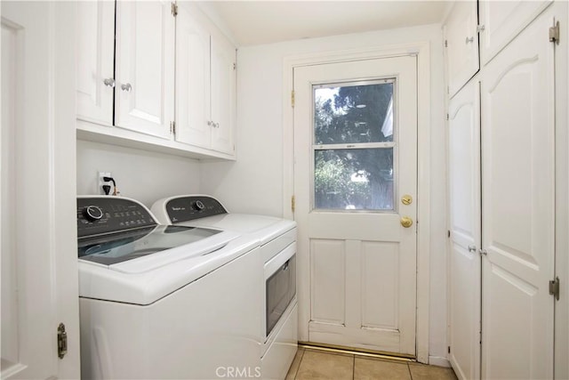 washroom with cabinets, light tile patterned floors, and washing machine and dryer