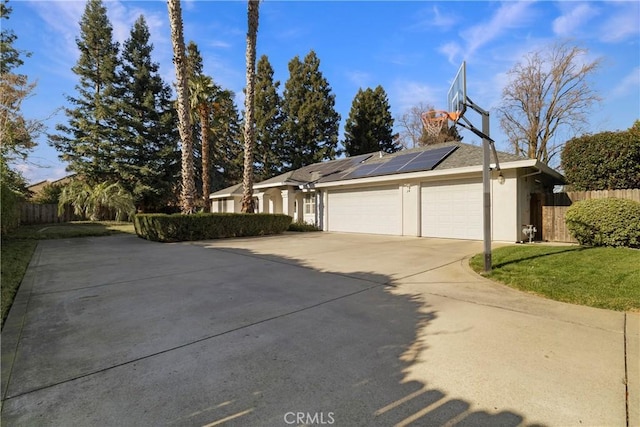 view of property exterior featuring a garage and solar panels