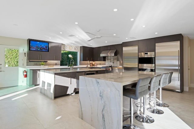 kitchen with a breakfast bar area, appliances with stainless steel finishes, and a large island