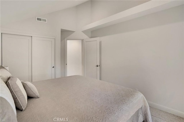 bedroom with light colored carpet, a closet, and vaulted ceiling