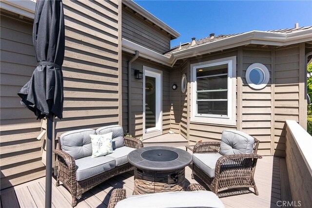 deck with an outdoor living space with a fire pit