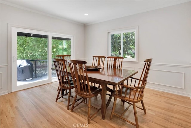 dining space featuring crown molding and light hardwood / wood-style flooring