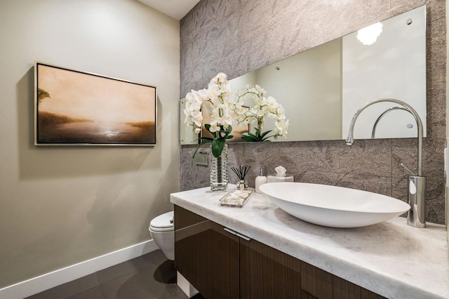 bathroom with tile patterned floors, vanity, toilet, and decorative backsplash