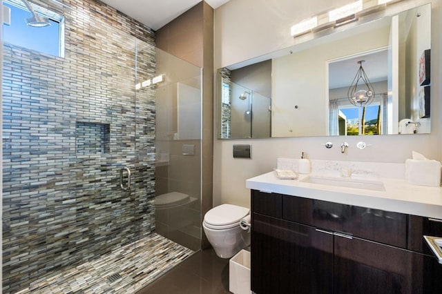 bathroom with a shower with door, vanity, and toilet