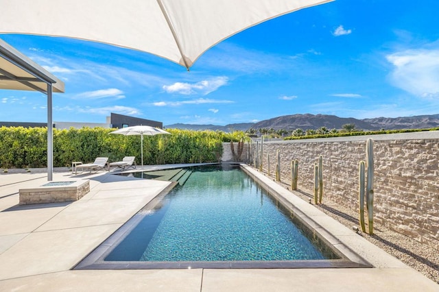 view of pool featuring a mountain view and a patio area