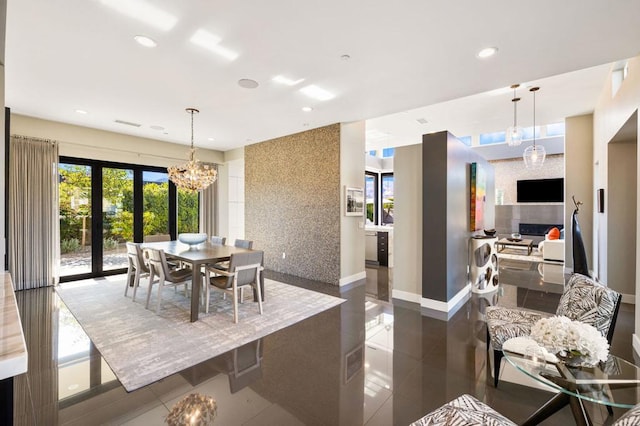 dining area featuring french doors, a fireplace, a chandelier, and tile patterned flooring