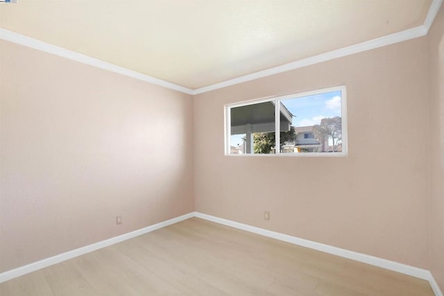 spare room featuring wood-type flooring and ornamental molding