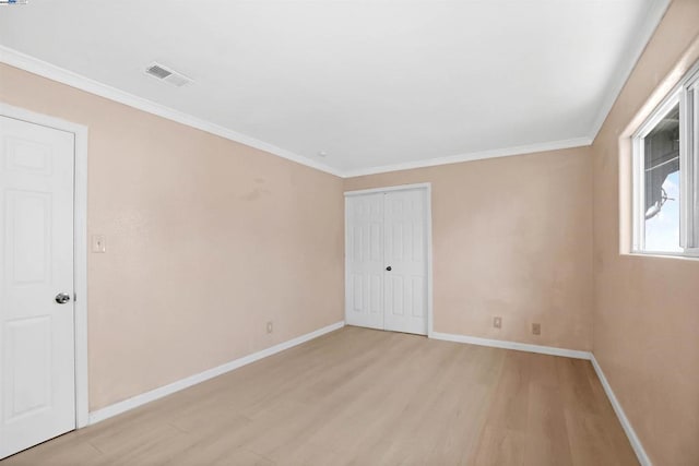 unfurnished room featuring crown molding and light wood-type flooring