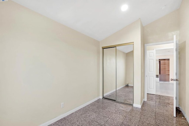 unfurnished bedroom featuring a closet and vaulted ceiling