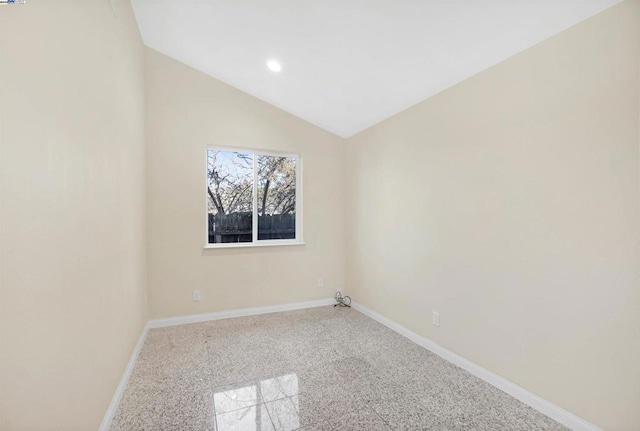 empty room featuring lofted ceiling