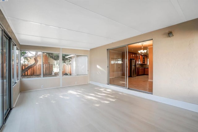 unfurnished sunroom with a notable chandelier