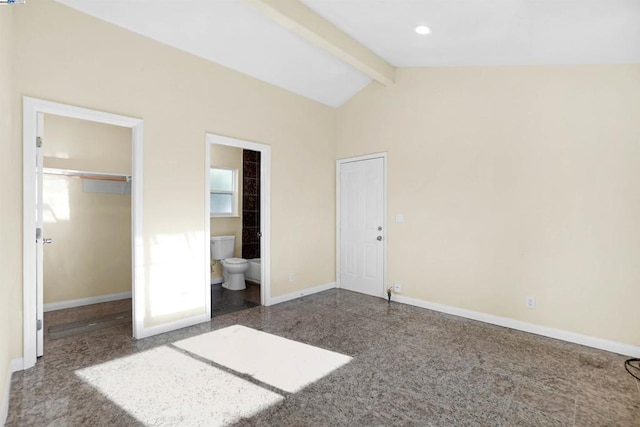 unfurnished bedroom featuring a spacious closet, ensuite bathroom, a closet, and lofted ceiling with beams