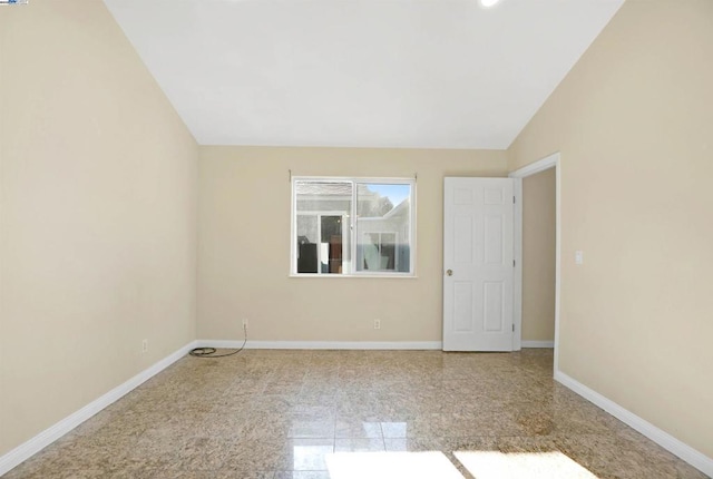 empty room featuring vaulted ceiling