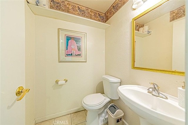 bathroom with toilet, tile patterned flooring, and sink