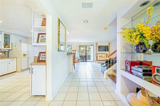 corridor with light tile patterned floors and crown molding