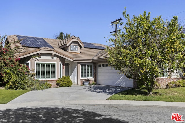 view of front facade with a garage and solar panels