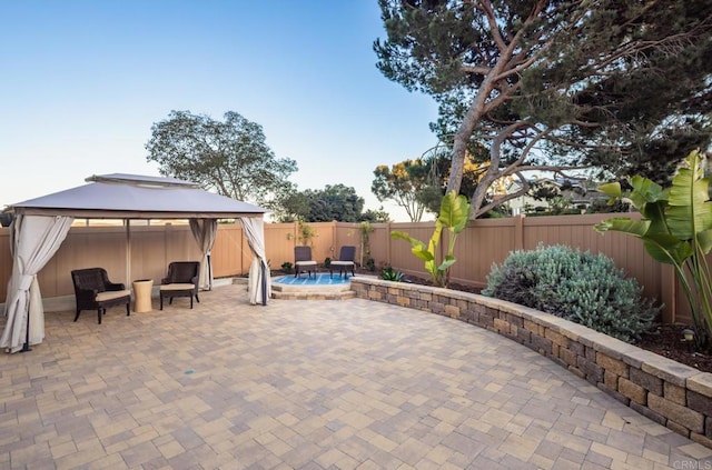 view of patio featuring a pool and a gazebo