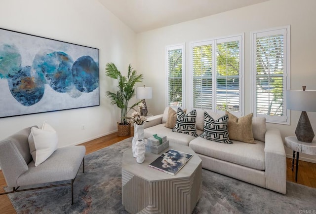 living room featuring dark wood-type flooring, a wealth of natural light, and vaulted ceiling