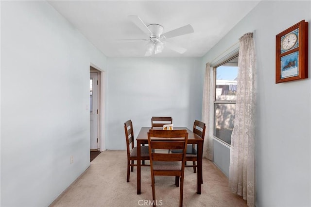 carpeted dining space featuring ceiling fan