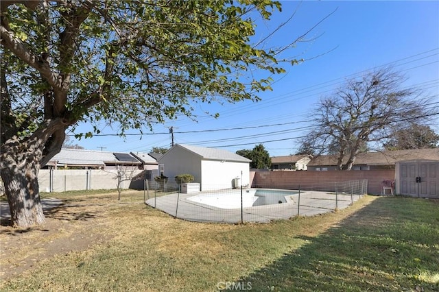 view of yard featuring an empty pool and a storage shed