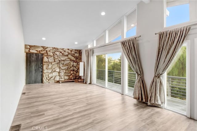 unfurnished living room featuring recessed lighting, visible vents, a high ceiling, and wood finished floors