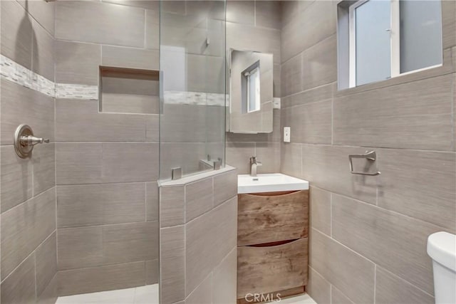 bathroom with toilet, vanity, and walk in shower