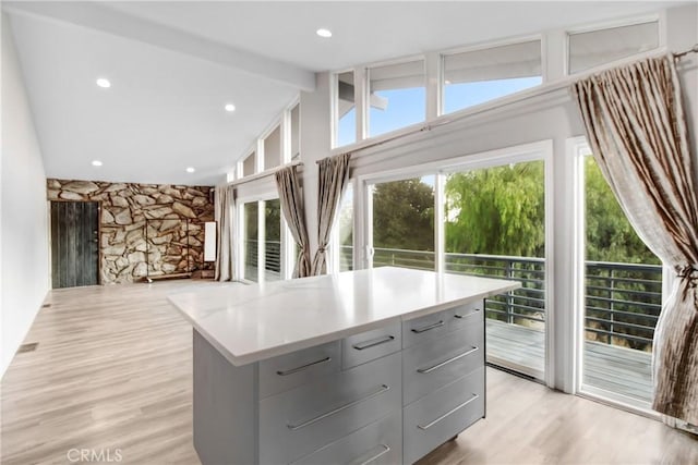 walk in closet with light wood finished floors and vaulted ceiling with beams