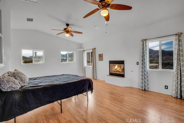 bedroom featuring ceiling fan, lofted ceiling, and light wood-type flooring