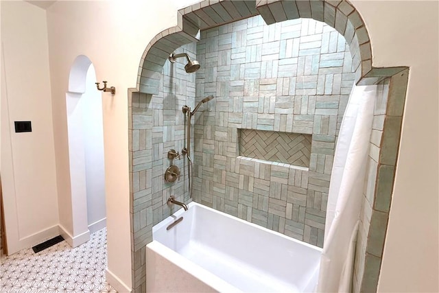 bathroom with shower / bath combo and baseboards