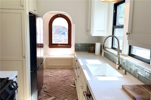 bathroom with brick floor, a washtub, and a sink