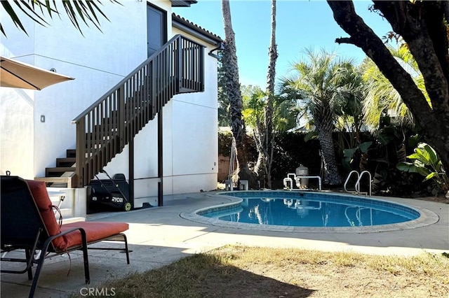 view of pool with a patio area, stairway, and a fenced in pool