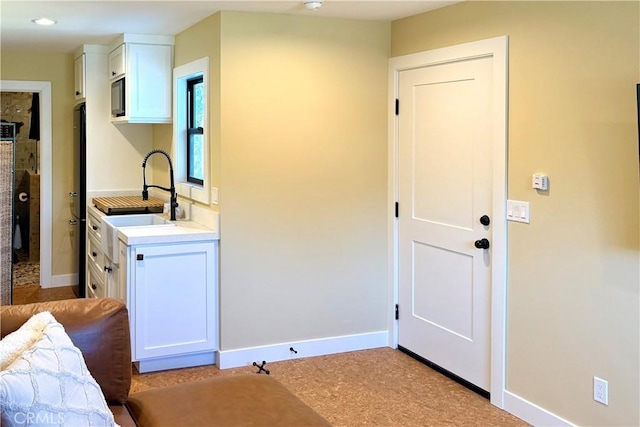 interior space featuring baseboards and a sink