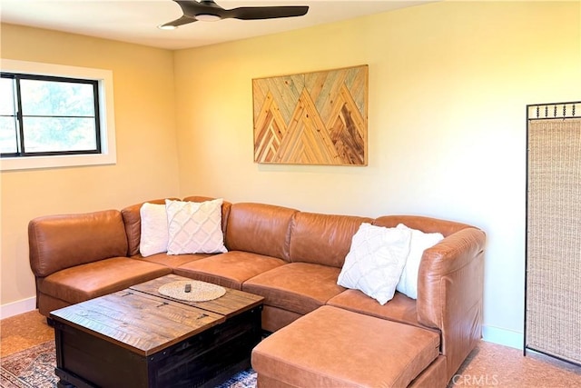 carpeted living room with ceiling fan and baseboards