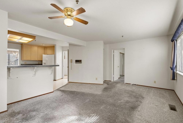 unfurnished living room featuring ceiling fan and light colored carpet