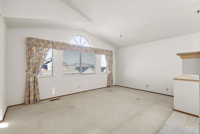 unfurnished living room with lofted ceiling and light colored carpet