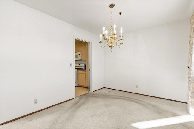 carpeted empty room featuring a chandelier