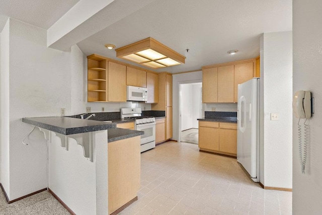 kitchen featuring light brown cabinets, kitchen peninsula, and white appliances