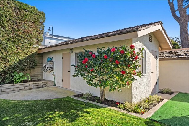 doorway to property featuring a patio area and a lawn