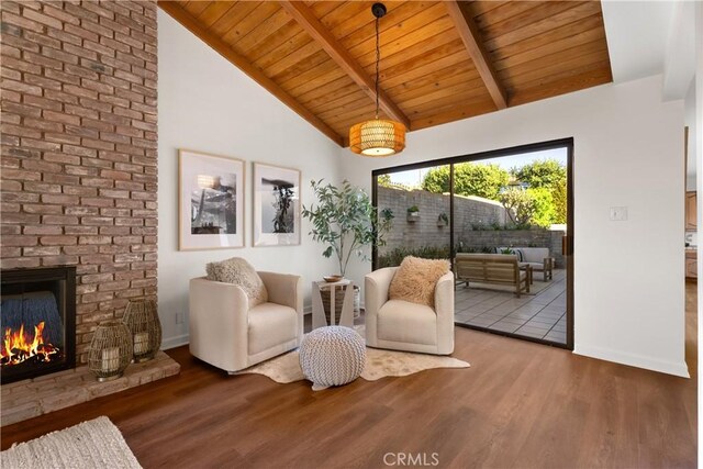 sitting room with hardwood / wood-style flooring, wooden ceiling, a fireplace, high vaulted ceiling, and beam ceiling