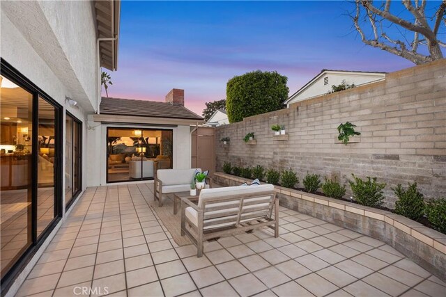 patio terrace at dusk featuring an outdoor hangout area