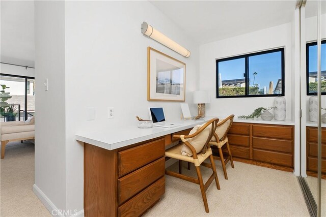 carpeted home office featuring built in desk