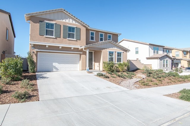 view of front facade with driveway, an attached garage, board and batten siding, and stucco siding