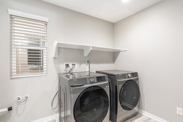 clothes washing area with separate washer and dryer and light hardwood / wood-style floors