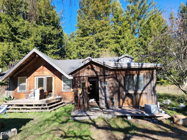 rear view of house with a deck and a lawn