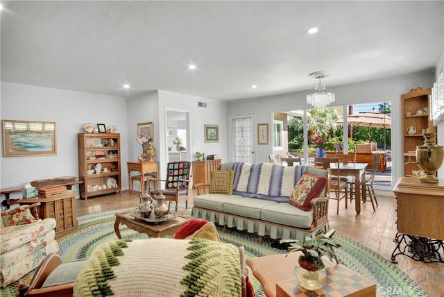 living room featuring light wood-type flooring and a notable chandelier