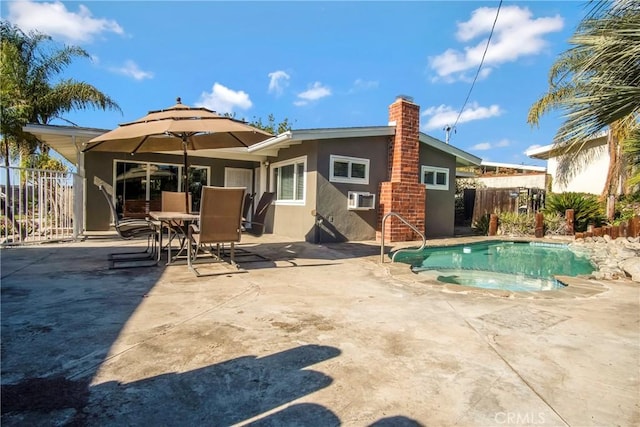 rear view of house with a fenced in pool and a patio