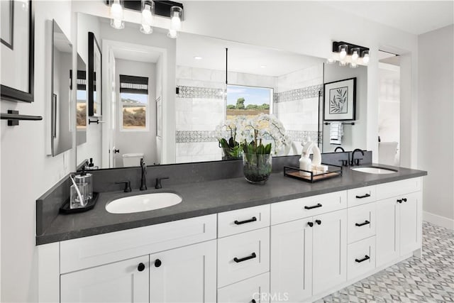 bathroom with a tile shower and vanity